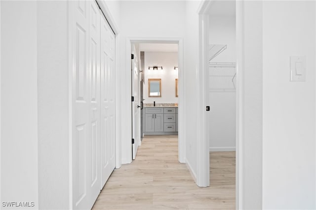 corridor featuring sink and light hardwood / wood-style flooring