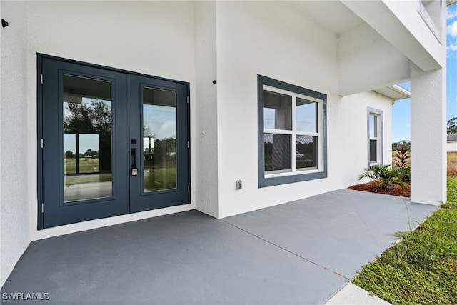 property entrance featuring a patio and french doors