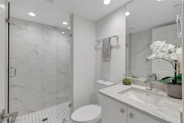 bathroom with vanity, toilet, and a shower with door