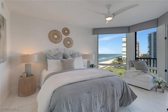 bedroom featuring ceiling fan and a water view