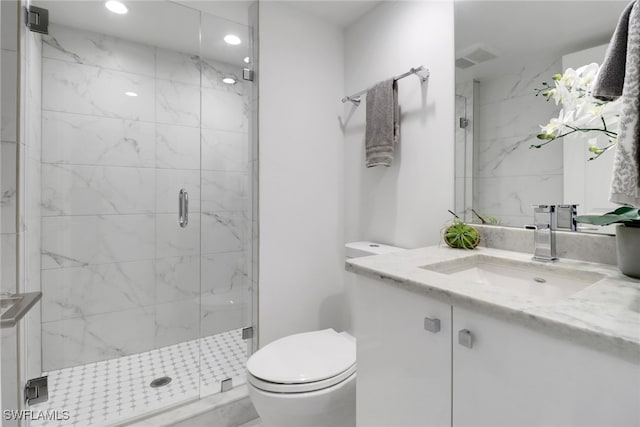 bathroom featuring vanity, toilet, and a shower with door