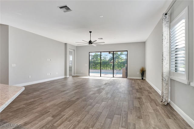 unfurnished living room featuring light hardwood / wood-style floors, a wealth of natural light, and ceiling fan