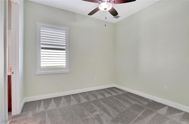 carpeted spare room featuring ceiling fan