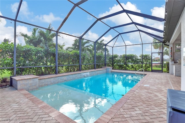 view of pool with pool water feature, a patio area, and a lanai