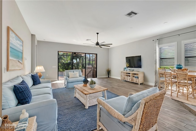 living room with wood-type flooring and ceiling fan