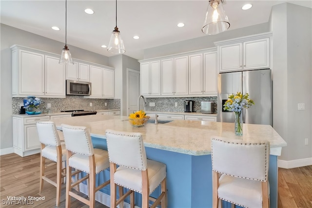 kitchen featuring a spacious island, stainless steel appliances, and light hardwood / wood-style floors