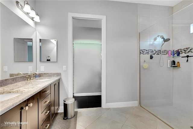 bathroom with vanity, a tile shower, and tile patterned floors