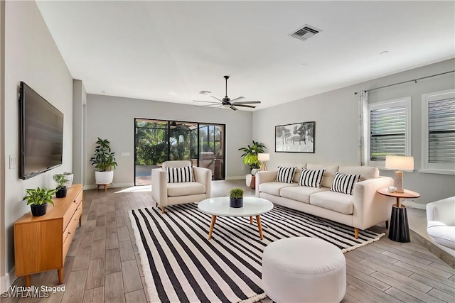 living room featuring ceiling fan and light wood-type flooring