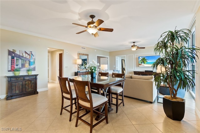 tiled dining space featuring ornamental molding and ceiling fan