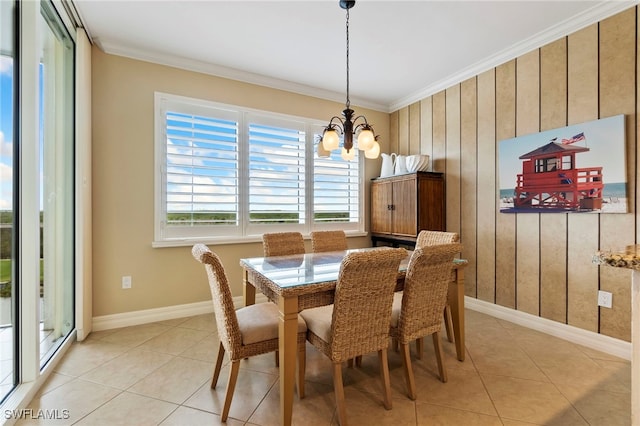 dining area with light tile patterned floors, ornamental molding, and a chandelier