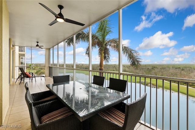 sunroom featuring a water view and ceiling fan