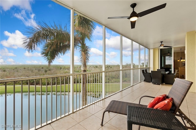 sunroom with a water view and ceiling fan