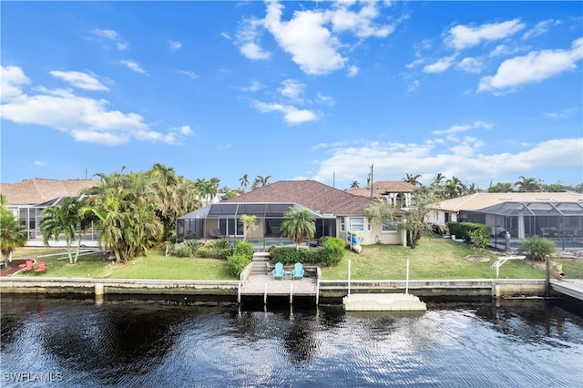 view of dock featuring a lawn, glass enclosure, and a water view