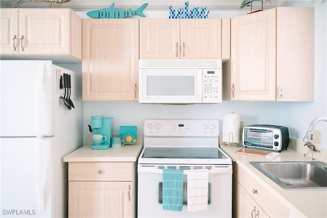 kitchen featuring light brown cabinetry, sink, and white appliances