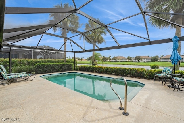 view of swimming pool with glass enclosure and a patio area