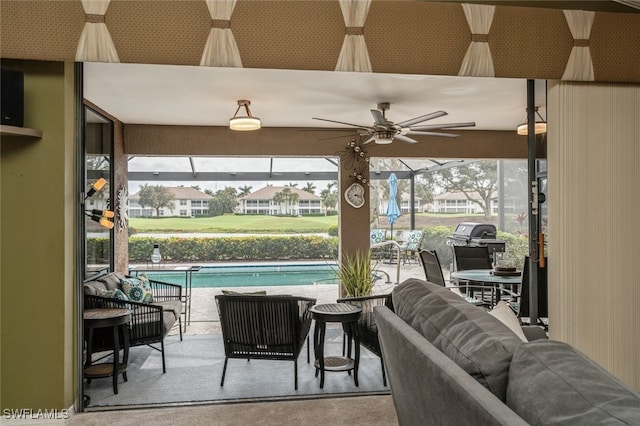 view of patio / terrace featuring an outdoor living space, ceiling fan, and glass enclosure