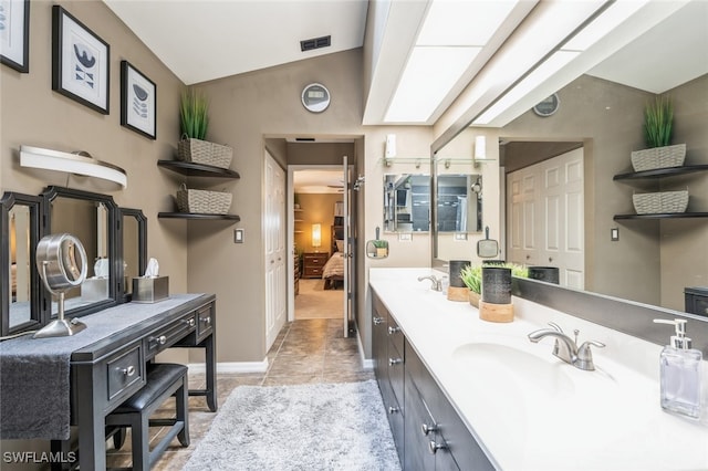 bathroom with vanity and lofted ceiling with skylight