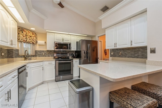 kitchen featuring kitchen peninsula, appliances with stainless steel finishes, and white cabinets