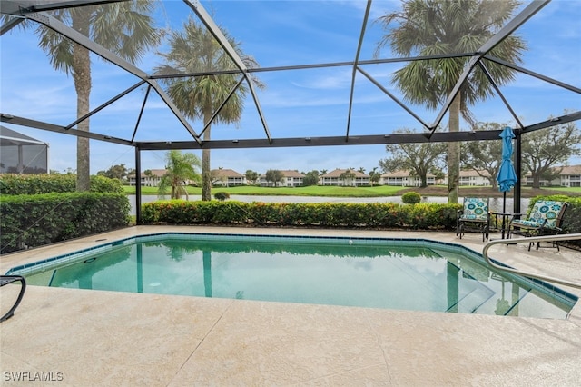 view of pool with a patio area and glass enclosure