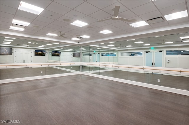 exercise area with ceiling fan and a paneled ceiling