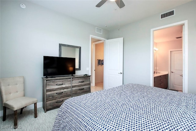 bedroom with ensuite bath, light carpet, and ceiling fan