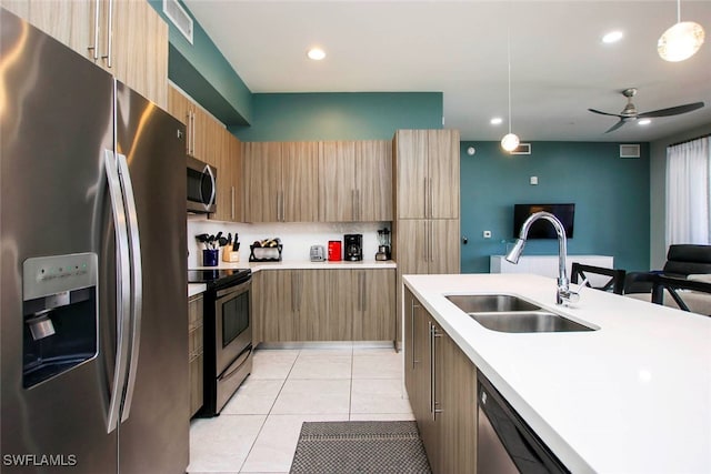 kitchen featuring sink, hanging light fixtures, ceiling fan, stainless steel appliances, and light tile patterned floors