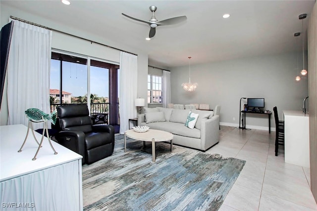 living room with ceiling fan with notable chandelier and light tile patterned floors