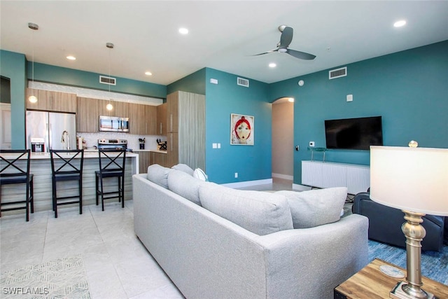 tiled living room with ceiling fan