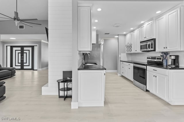 kitchen with white cabinetry, sink, stainless steel appliances, and light wood-type flooring