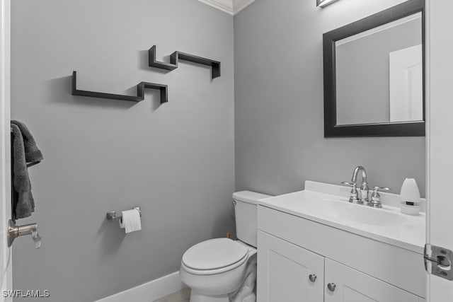 bathroom with vanity, ornamental molding, and toilet