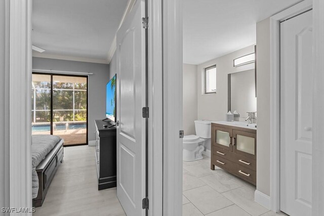 bathroom featuring vanity, a healthy amount of sunlight, toilet, and crown molding