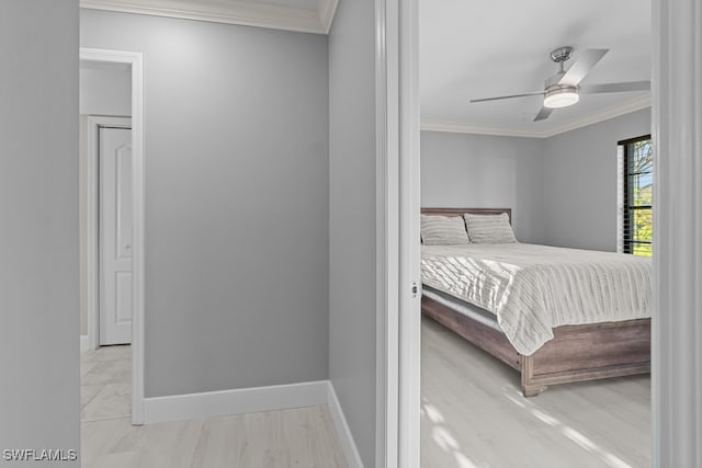 bedroom featuring ceiling fan, light wood-type flooring, and crown molding