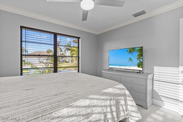 carpeted bedroom with ceiling fan and crown molding