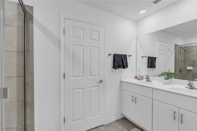 bathroom with tile patterned flooring, vanity, and an enclosed shower