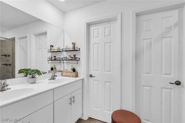 bathroom featuring a tile shower and vanity