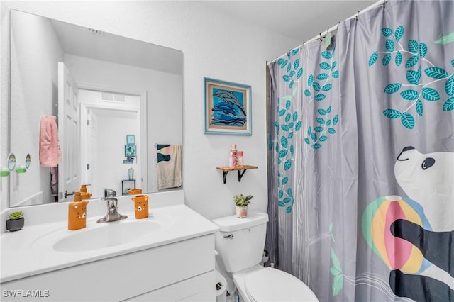 bathroom featuring curtained shower, vanity, and toilet