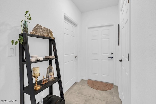 doorway with light tile patterned floors