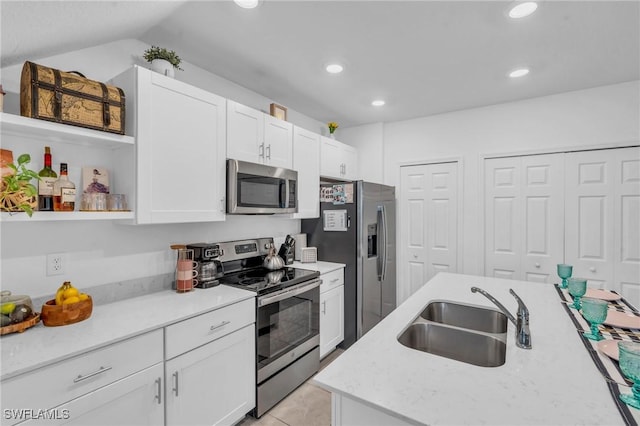 kitchen featuring sink, white cabinets, lofted ceiling, and appliances with stainless steel finishes