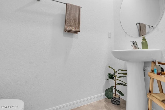 bathroom with toilet and tile patterned floors