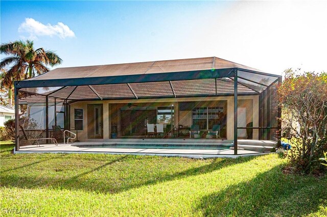 back of property featuring a patio, a yard, and glass enclosure