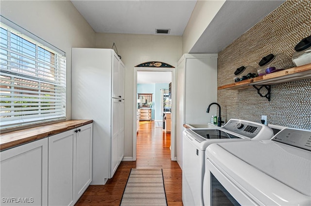 washroom featuring cabinets, dark hardwood / wood-style floors, sink, and washer and dryer