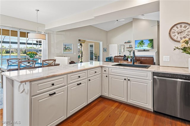 kitchen with white cabinetry, lofted ceiling, sink, stainless steel dishwasher, and kitchen peninsula