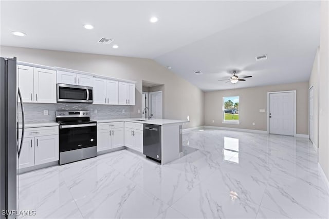 kitchen with kitchen peninsula, ceiling fan, appliances with stainless steel finishes, sink, and white cabinetry