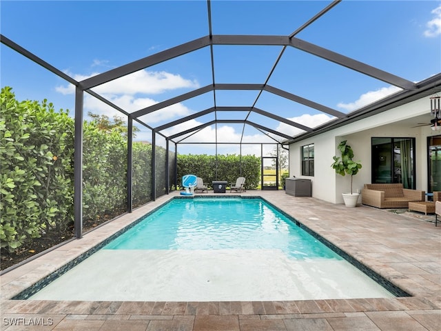 view of pool with an outdoor living space, a lanai, and a patio area