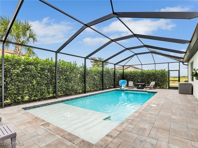 view of swimming pool with a patio area and a lanai