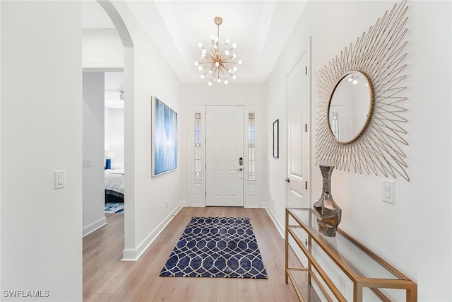 foyer entrance with a chandelier and light wood-type flooring