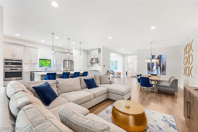 living room with an inviting chandelier and light wood-type flooring