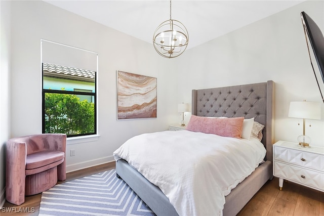 bedroom featuring dark hardwood / wood-style flooring and an inviting chandelier