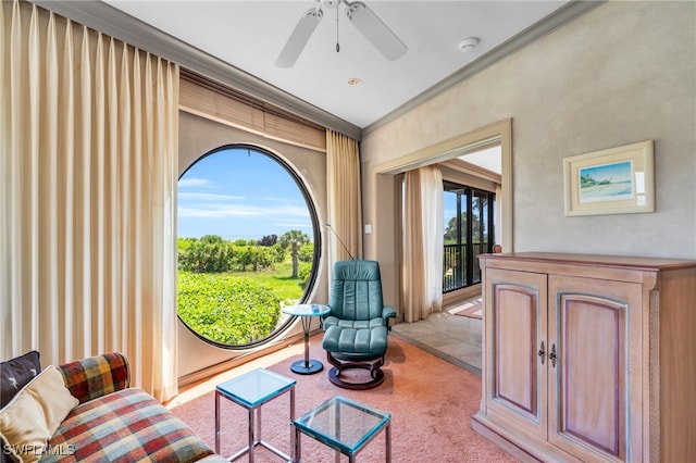 living area featuring light colored carpet, ceiling fan, and crown molding