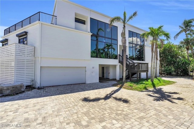 contemporary home featuring a balcony and a garage